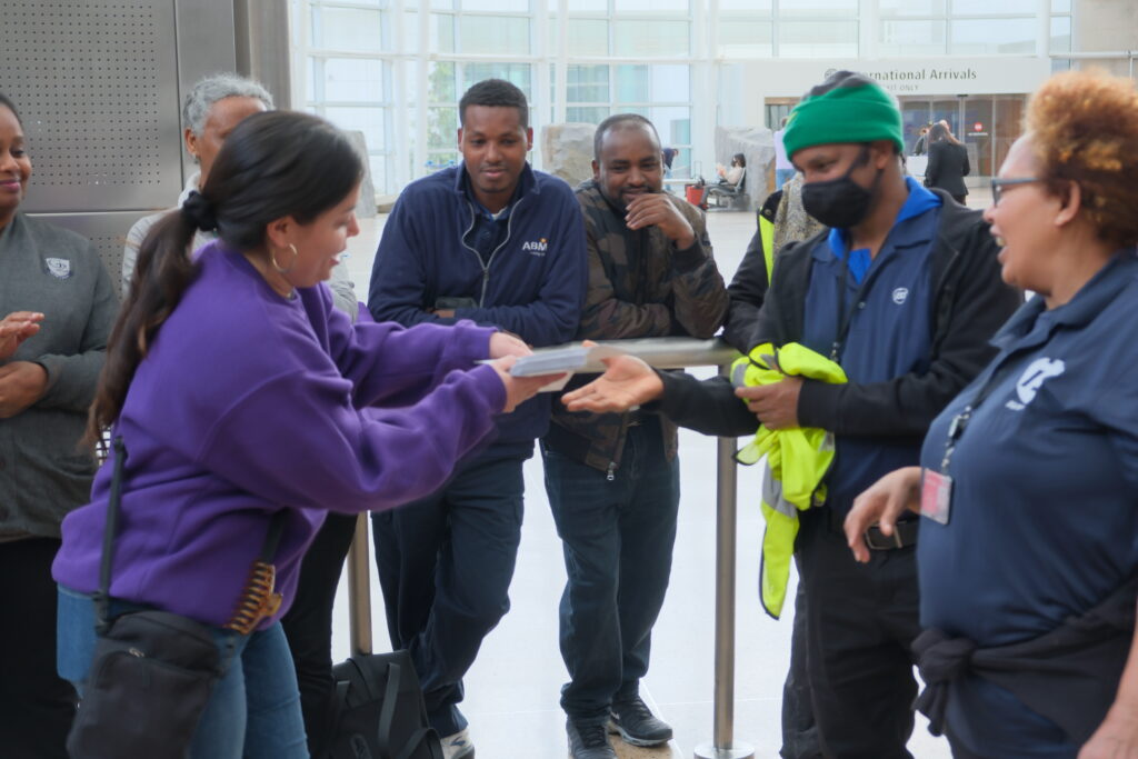 SEIU6 President Zenia Javalera distributes backpay checks to Whayne airport workers at SeaTac.